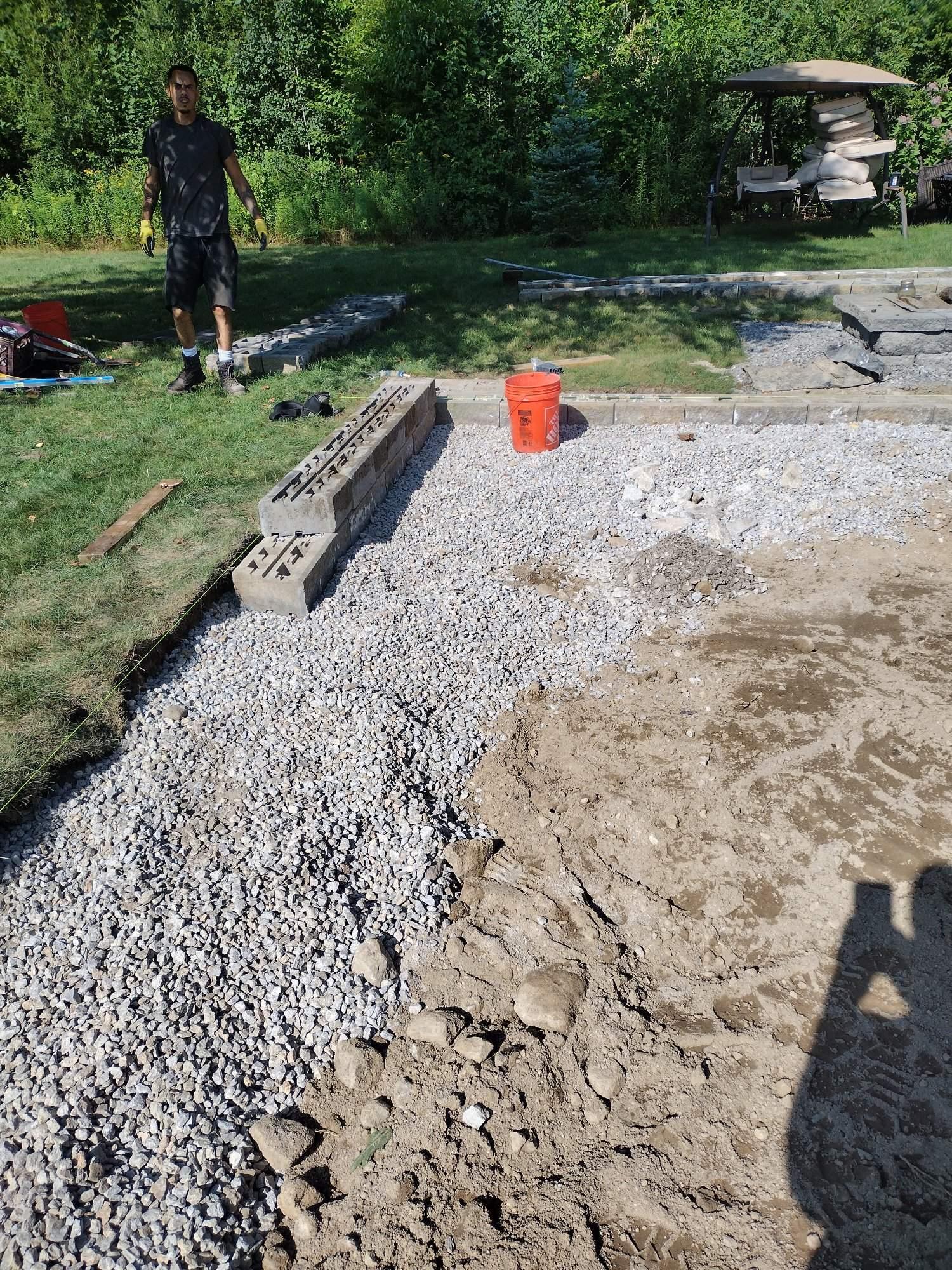 Paver patio installation in progress with segmental block seat walls built  in Luster, MA and area excavated, KRD Landscaping hardscape contractor.